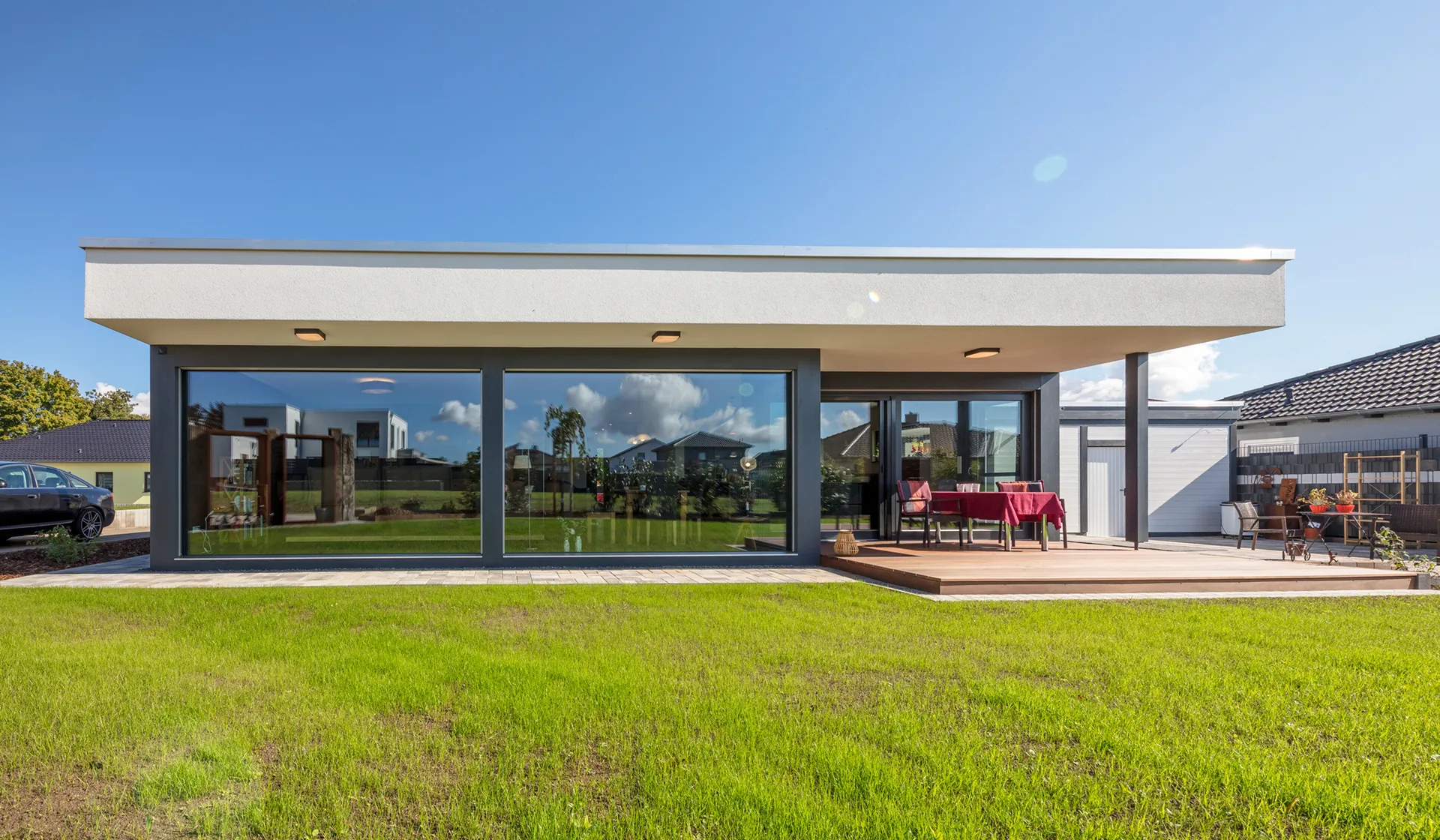 Bauhaus-Bungalow mit Carport von Meisterstück-HAUS Gartenansicht
