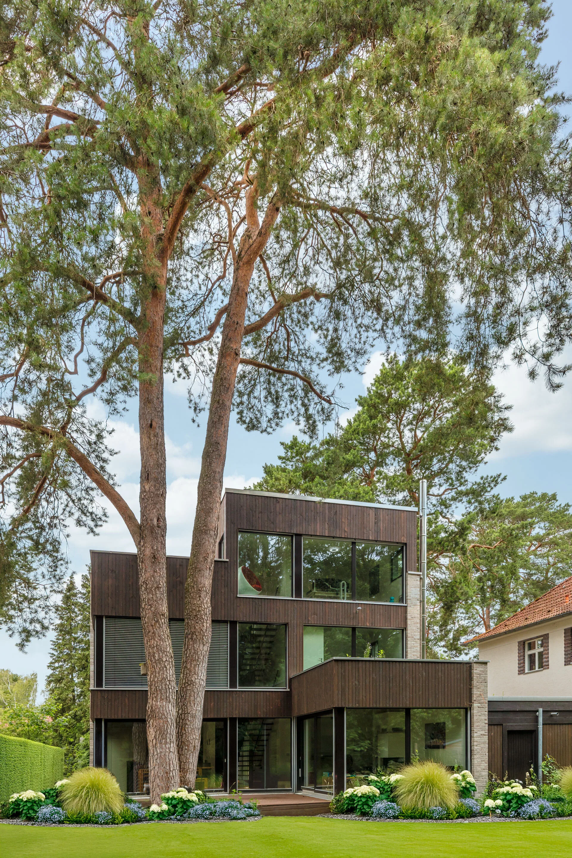 Bauhausvilla mit Klinker- und Holzfassade von Meisterstueck Haus Rückansicht